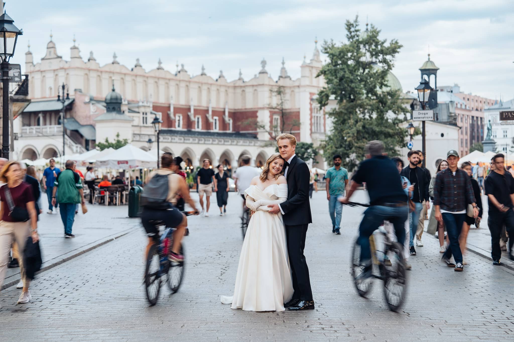 sesja ślubna Kraków para młoda w plenerze złota godzina ludzie w tle sukiennice latarnie usmiechy